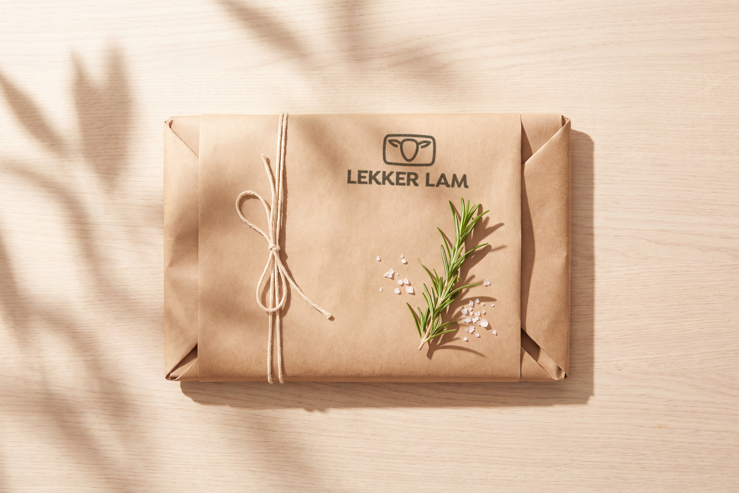 Kraft paper parcel tied with string and stamped with the Lekker Lam logo