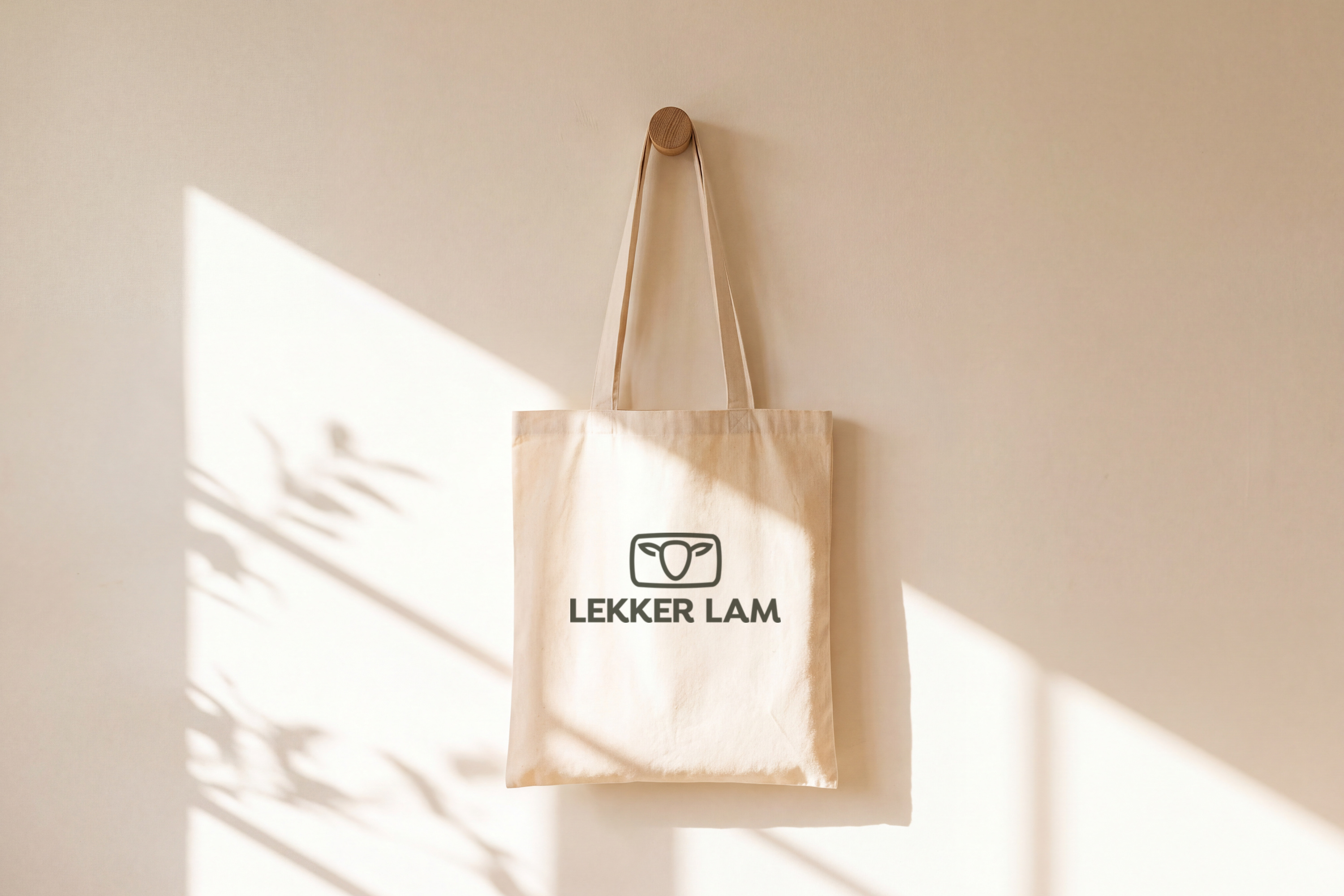 Canvas tote bag with the Lekker Lam logo hanging on a wall