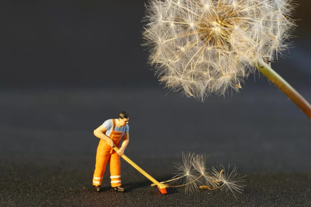 Shallow Focus Photo of Man Holding Floor Brush Ceramic Figurine
