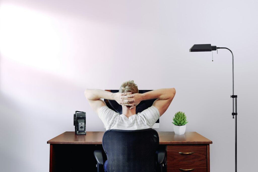 man holding his head while sitting on chair near computer desk. Thinking, Should I Start a Business in 2025